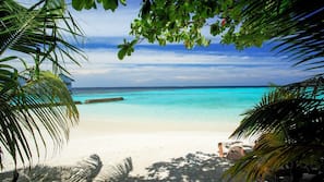Privatstrand, weißer Sandstrand, Strandtücher, Windsurfen