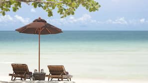 Am Strand, weißer Sandstrand, Liegestühle, Sonnenschirme