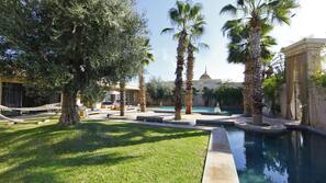 Una piscina al aire libre, sombrillas, tumbonas