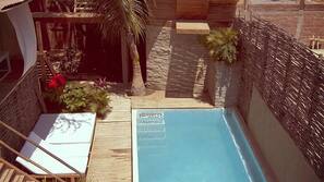 Una piscina cubierta, una piscina al aire libre, sombrillas, tumbonas