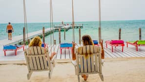 On the beach, white sand, sun loungers, beach towels