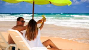 On the beach, white sand, sun-loungers, beach umbrellas