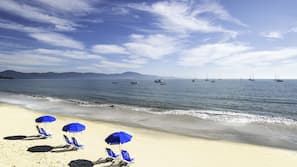 On the beach, white sand, sun-loungers, beach umbrellas