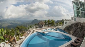 Una piscina al aire libre, sombrillas, tumbonas