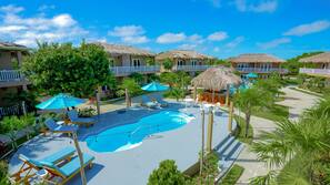 Una piscina al aire libre, sombrillas, tumbonas