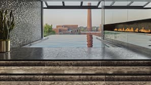 Una piscina cubierta, una piscina al aire libre, sombrillas, tumbonas