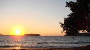 Na praia, barracas de praia de cortesia, guarda-sóis, toalhas de praia