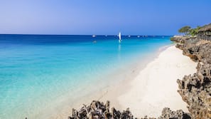 Plage privée, sable blanc, chaises longues, parasols