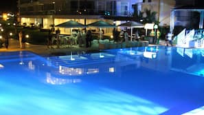 Una piscina al aire libre, sombrillas, tumbonas