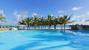 Una piscina al aire libre, sombrillas, tumbonas