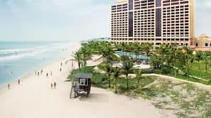 Trên bãi biển, ghế dài tắm nắng, dù trên bãi biển, khăn tắm biển