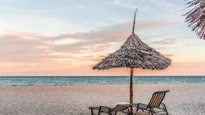 Playa privada, arena blanca, sombrillas y toallas de playa