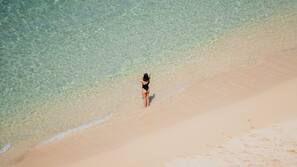 On the beach, white sand, sun loungers, beach towels