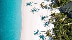 On the beach, white sand, free beach cabanas, beach umbrellas