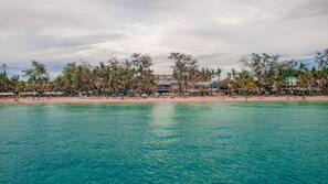 On the beach, white sand, sun loungers, beach umbrellas
