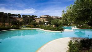 Una piscina al aire libre de temporada, sombrillas