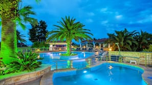 Outdoor pool, a waterfall pool, pool umbrellas, sun loungers