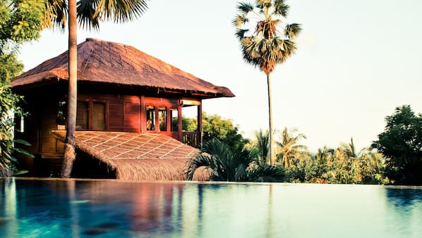 Een buitenzwembad, een infinity pool, parasols voor strand/zwembad