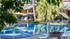 Una piscina al aire libre, sombrillas, tumbonas