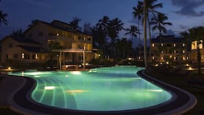 Una piscina al aire libre, sombrillas, tumbonas