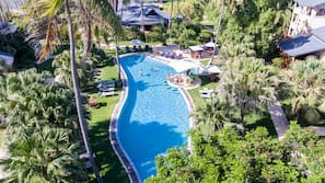 Una piscina al aire libre, sombrillas, tumbonas