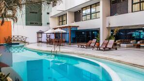 Piscine extérieure, parasols de plage, chaises longues