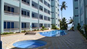Una piscina al aire libre, sombrillas, tumbonas