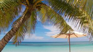 On the beach, white sand, sun loungers, beach umbrellas