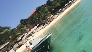 On the beach, white sand, sun loungers, beach umbrellas