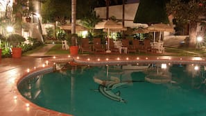 Una piscina al aire libre, tumbonas