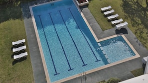 Una piscina al aire libre de temporada, sombrillas, tumbonas