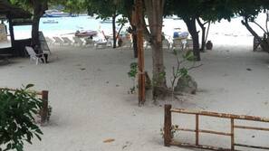 Plage, sable blanc, chaises longues, parasols