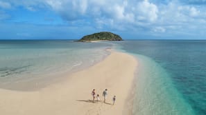 On the beach, white sand, sun loungers, beach umbrellas