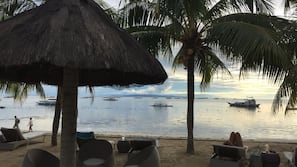 On the beach, white sand, sun-loungers, beach towels