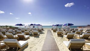 On the beach, sun-loungers, beach umbrellas, beach bar