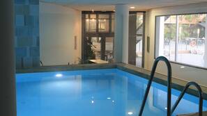 Una piscina al aire libre, sombrillas, tumbonas