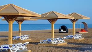 Privatstrand, Liegestühle, Sonnenschirme, Volleyball