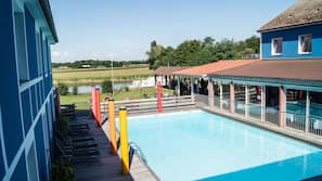 Una piscina al aire libre, sombrillas