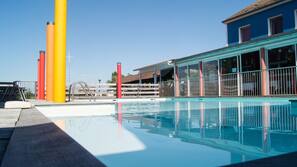 Una piscina al aire libre, sombrillas