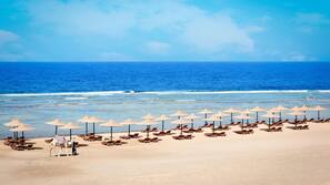 Praia particular, guarda-sóis, toalhas de praia