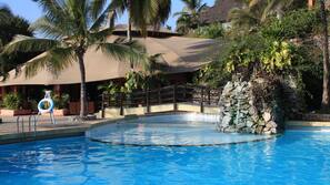 Una piscina cubierta, una piscina al aire libre, tumbonas