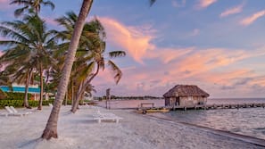 On the beach, white sand, sun-loungers, beach umbrellas
