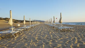 Sulla spiaggia, lettini da mare, ombrelloni