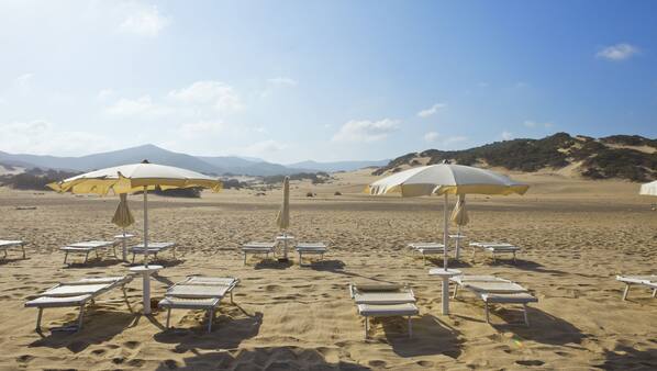 Sulla spiaggia, lettini da mare, ombrelloni