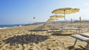 Sulla spiaggia, lettini da mare, ombrelloni