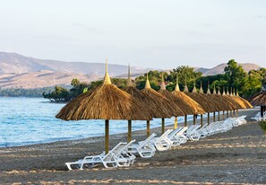 On the beach, white sand, sun loungers, beach towels