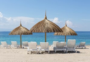 On the beach, white sand, sun loungers, beach towels