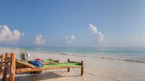 Plage, sable blanc, chaises longues, parasols