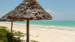 Plage, sable blanc, chaises longues, parasols