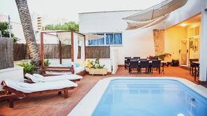 Una piscina al aire libre de temporada, sombrillas, tumbonas